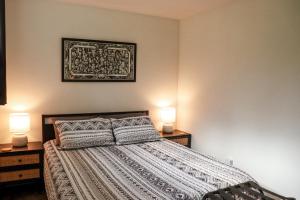 a bedroom with a bed with two lamps and a picture on the wall at The Kalamoir Suite in West Kelowna +15 photos