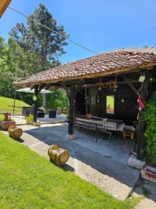 a wooden pavilion with a bench in a yard at Topola vikendica in Topola