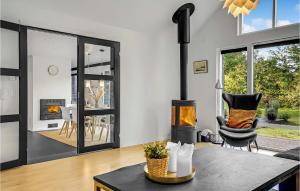 a living room with a fireplace and a chair at 3 Bedroom Amazing Home In Knebel in Knebel