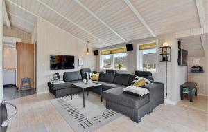 a living room with a couch and a table at Holiday Home Pøt Strandby Ii Juelsminde I in Sønderby
