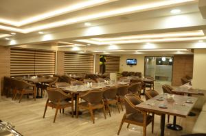 a restaurant with tables and chairs in a room at The Ved Mantra in Gwalior
