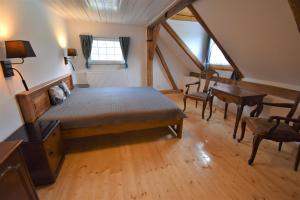 a bedroom with a bed and a desk in a attic at Penzion U Ovečky in Jeseník
