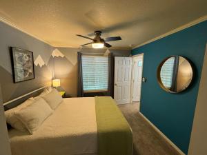 a bedroom with a bed with a ceiling fan and a mirror at Charming Downtown Cottage in Grass Valley