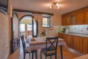 a kitchen with a table with chairs and a table and a kitchen with a table at Apartment Brezina - Lovran - Liganj in Lovran