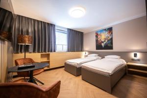 a hotel room with two beds and a table at Penzion MartInn in Martin