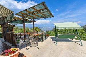 a patio with a table and a green umbrella at Apartment Brezina - Lovran - Liganj in Lovran