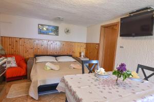 a bedroom with a bed and a table and a tv at Apartment Brezina - Lovran - Liganj in Lovran