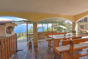 a house with a patio with a table and an umbrella at Apartment Brezina - Lovran - Liganj in Lovran +15 photos