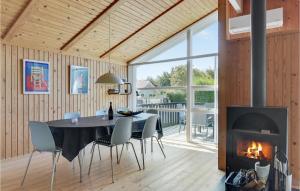 a dining room with a table and a fireplace at Holiday Home Egemose Sydals I in Skovby