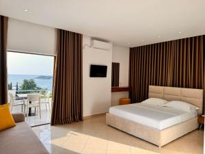 a bedroom with a bed and a view of the ocean at Dine Hotel in Ksamil