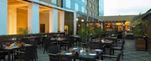 a restaurant with tables and chairs in front of a building at Royal Orchid Central, Pune in Pune