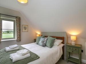 sypialnia z łóżkiem i oknem z ręcznikami w obiekcie 4 Wellacres Cottage w mieście Moreton-in-Marsh
