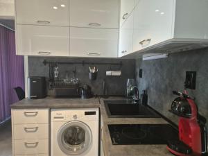a kitchen with a sink and a washing machine at Ivon Apartments in Sozopol