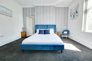 a bedroom with a blue bed and a blue chair at Winwood House in Goole