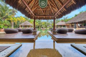 un complejo con piscina, mesas y sombrillas de paja en Haixa A107, en Higuera Blanca