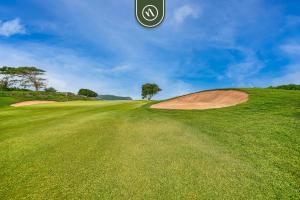 Un campo de golf verde con un árbol en una colina en Haixa A107, en Higuera Blanca