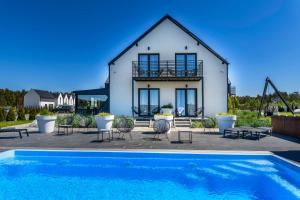 a house with a swimming pool in front of a house at Loox Ostrovo- Boutique House-noclegi nad morzem in Ostrowo
