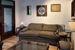 ein Wohnzimmer mit einer Couch und einer Uhr an der Wand in der Unterkunft Riverfront Mountain Memories in Deming