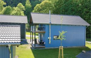 ein blaues Gebäude mit einem Balkon und einem Baum in der Unterkunft Ferienhausdorf Thale in Thale
