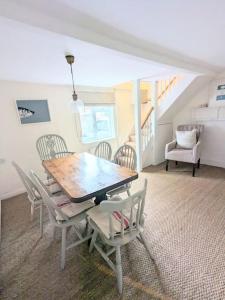 une salle à manger avec une table et des chaises en bois dans l'établissement Lobster Pot Cottage, à Fulmodeston