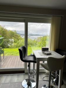 a table and two chairs in front of a window at Harstad, all seasons in Harstad