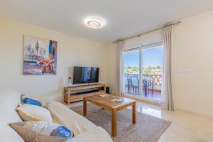 un salon avec un canapé et une télévision dans l'établissement El Rinconcito, à Torre de Benagalbón