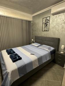 a bedroom with a bed with a blue and white blanket at Ivon Apartments in Sozopol