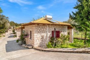 a small stone house with a red door at Apanema Mindfulness Resort Lefkada - ultra fast Starlink WiFi in 2025 in Asprogerakata