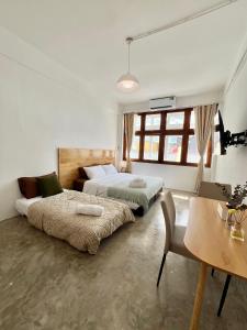 a bedroom with two beds and a table and chairs at Sabay Home in Bangkok