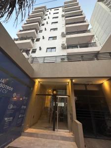 a tall white building with a door in front of it at Departamento monoambiente sobre calle San Martin, a metros del casco historico in Santa Fe