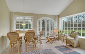 ホーンバックにあるGorgeous Home In Hornbæk With Kitchenのテーブルと椅子と窓のあるダイニングルーム