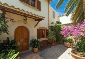 a building with a wooden door and a wooden bench at Schönes Haus mit Pool direkt am Meer in Costa des Pins
