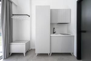 a white kitchen with a sink and a counter at Astrum Luxury Suites in Vourvourou