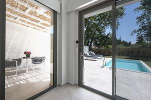 a sliding glass door leading to a patio with a pool at Astrum Luxury Suites in Vourvourou