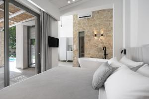 a bedroom with a bed and a bath tub at Astrum Luxury Suites in Vourvourou