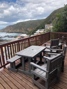 ヘロルズ・ベイにあるDankepa beach houseのピクニックテーブルと椅子(海を見渡すデッキに設置)