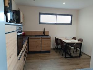 a kitchen with a table and a table and chairs at Dume et Coco F2 55 M2 Vue mer in Taglio-Isolaccio +9 photos