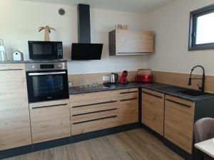 a kitchen with wooden cabinets and a stove top oven at Dume et Coco F2 55 M2 Vue mer in Taglio-Isolaccio