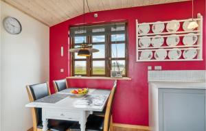 een eetkamer met een tafel en een rode muur bij 1 Bedroom Stunning Home In Allingåbro in Allingåbro