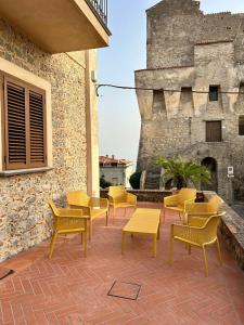 a patio with chairs and tables in front of a building at Case Vacanze Torre Petrosa in Villammare