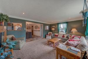 una sala de estar con un sofá y una mesa en Wildflower Cottage - Cute Home with Yard & Bonfire, en Pepin
