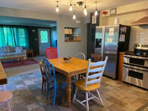 Una cocina y un comedor con mesa y sillas de madera. en Wildflower Cottage - Cute Home with Yard & Bonfire, en Pepin