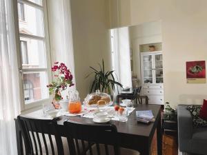 una mesa de comedor con un tazón de naranjas. en La Casa di Ringhiera - silenzioso appartamento di charme con balcone nel quadrilatero romano, en Turín
