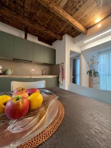 a bowl of apples and oranges on a table in a kitchen at Residenza Alice in Arco