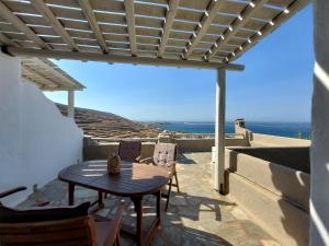 a table and chairs on a patio with a view of the ocean at Paesino in Kionia