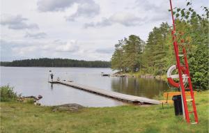 a man standing at a dock on a lake at Nice Home In Vetlanda With Wifi in Stenberga