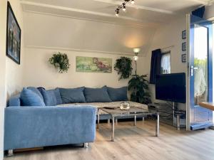 安于姆Ferienhaus in Anjum mit Kleinem Balkon的客厅里有一张蓝色的沙发和一张桌子