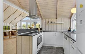 a kitchen with white cabinets and black counter tops at 3 Bedroom Cozy Home In Børkop in Børkop