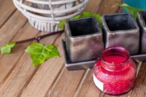 a red glass jar sitting on a wooden table at Apanema Mindfulness Resort Lefkada - ultra fast Starlink WiFi in 2025 in Asprogerakata