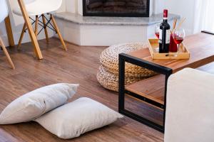 a living room with a table with a wine bottle and pillows at Apanema Mindfulness Resort Lefkada - ultra fast Starlink WiFi in 2025 in Asprogerakata